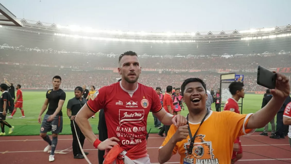 Seorang The Jak Mania brrfoto dengan gelandang persija Jakarta Marco Simic seusai pertandingan.