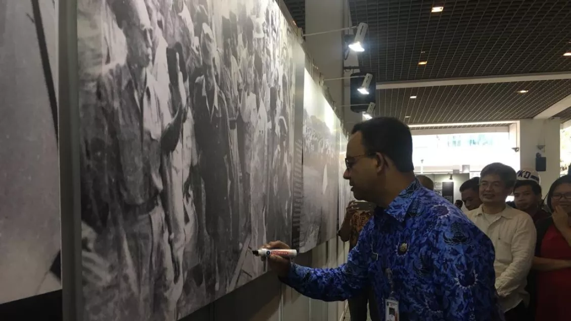 Anies Baswedan menandatangani salah satu foto yang dipamerkan sebagai simbolik bahwa pameran foto peristiwa IKADA resmi dibuka