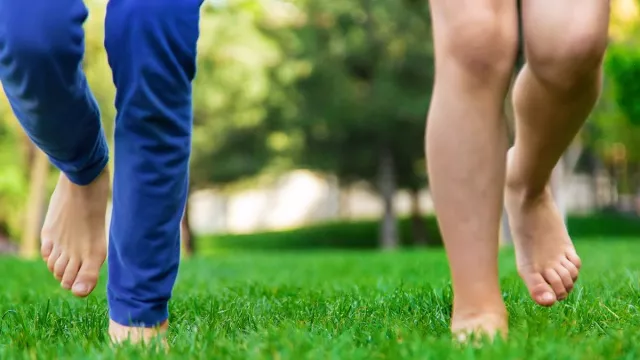 3 Manfaat Utama Berjalan di Atas Rumput Tanpa Alas Kaki - GenPI.co